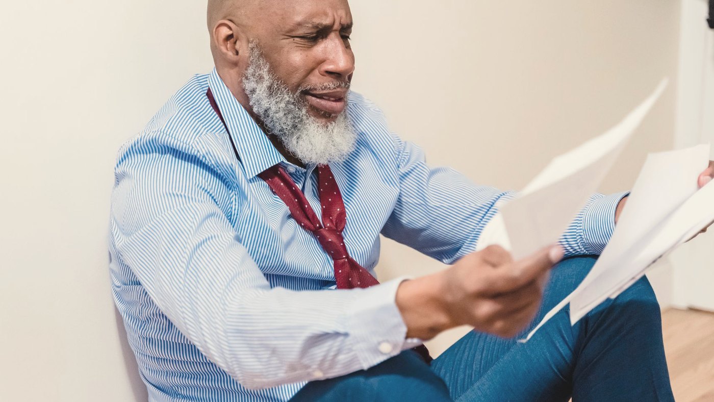 Bearded man sitting on the floor with a worried look