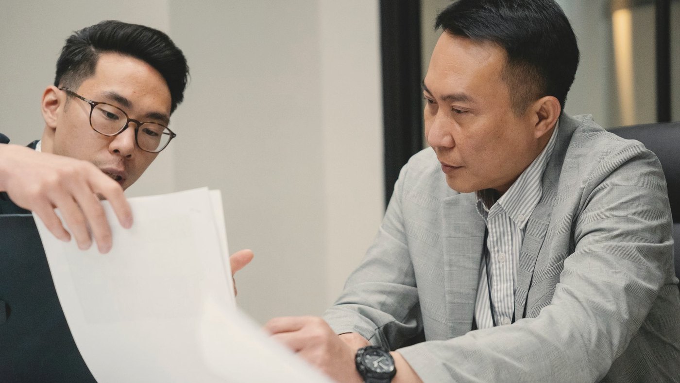 Two professional men engaged in a focused discussion in office