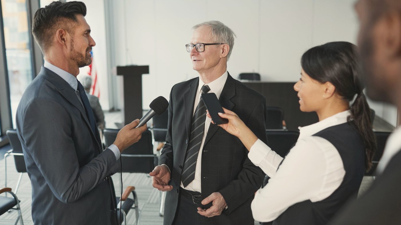 Journalists interviewing a senior executive in a formal office