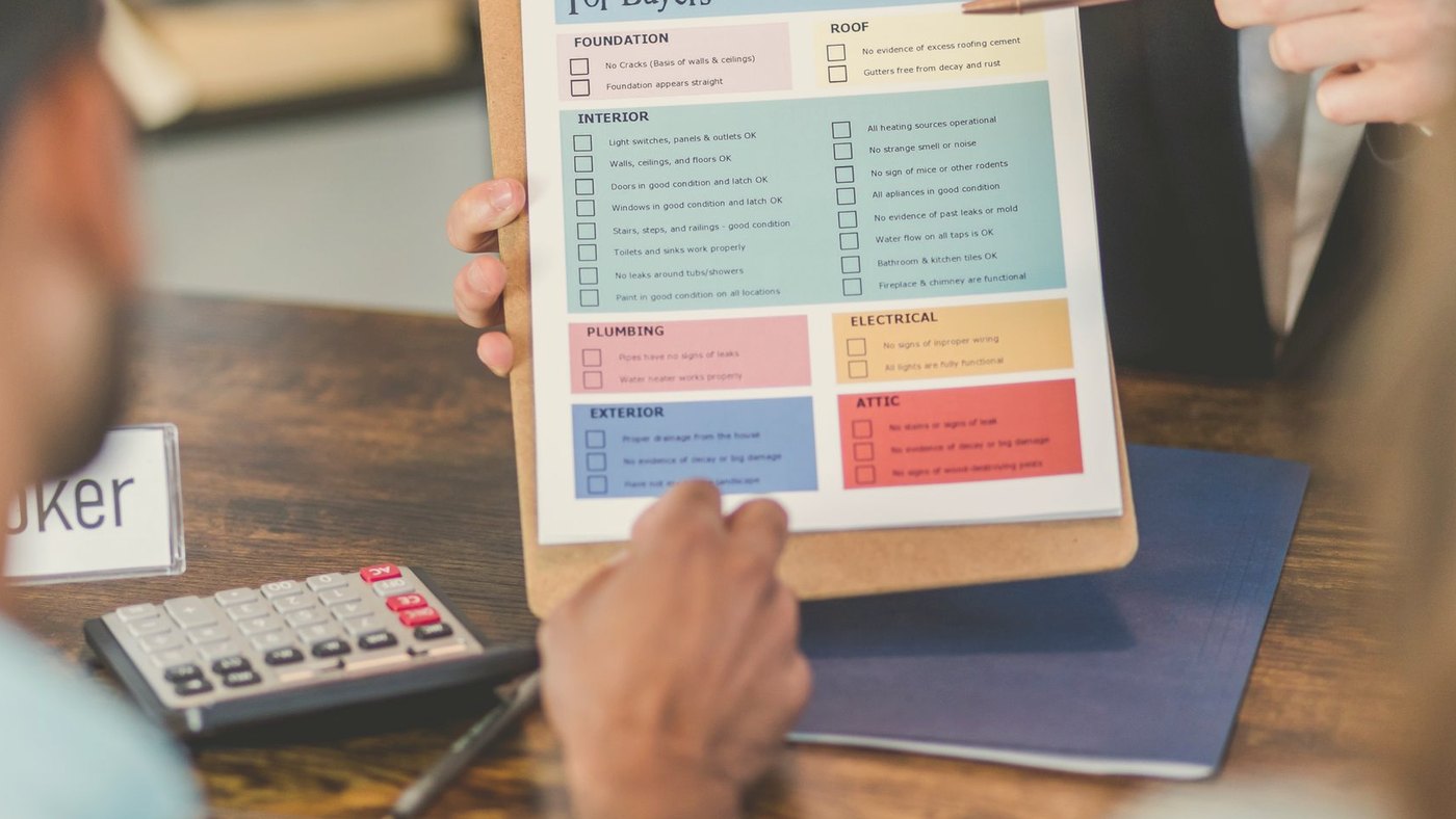 Realtor going through a checklist with clients at a table
