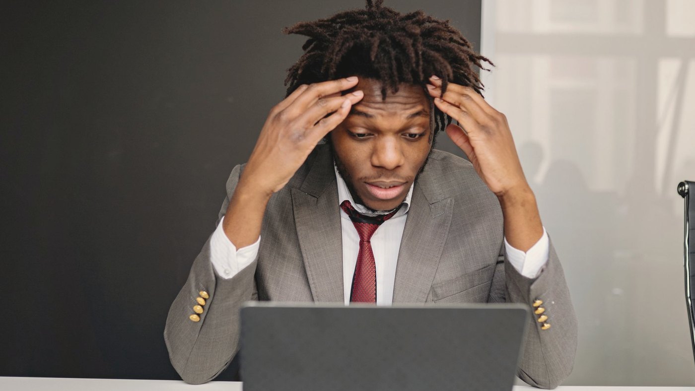 Businessman with his hand on his forehead over a laptop