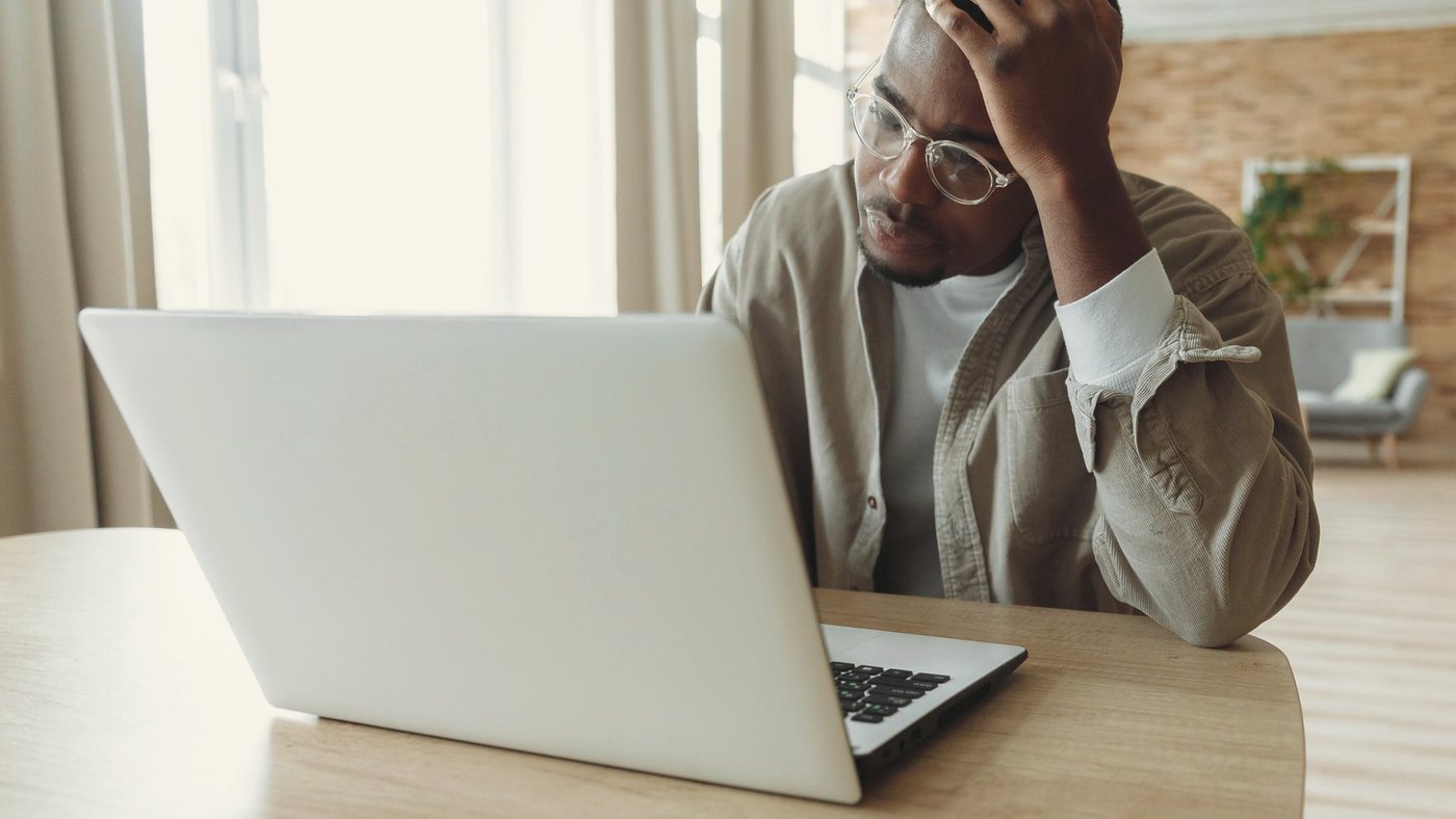 Man stressed while dealing with issues on a laptop
