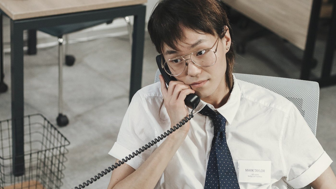 Man in a headset answers a call at a desk
