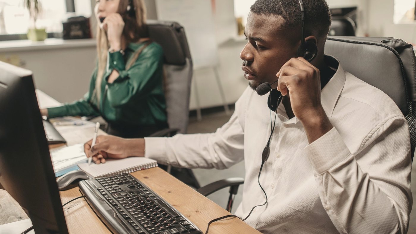 Team of customer service representatives working at computers and answering calls