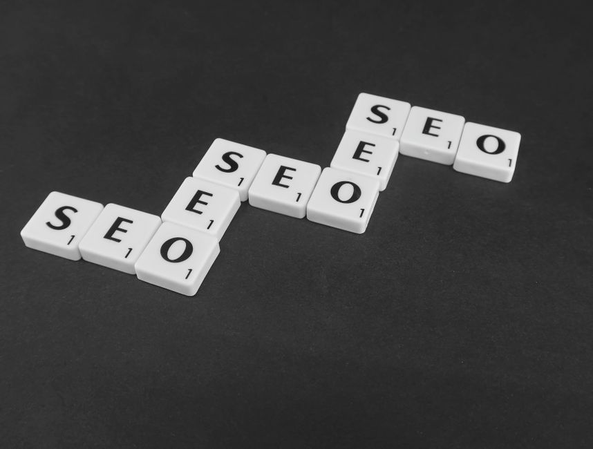 White Scrabble tiles spelling SEO on a black surface