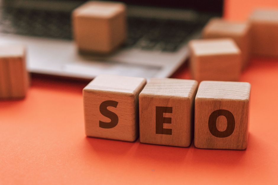 Wooden letter blocks spelling SEO resting on a laptop keyboard