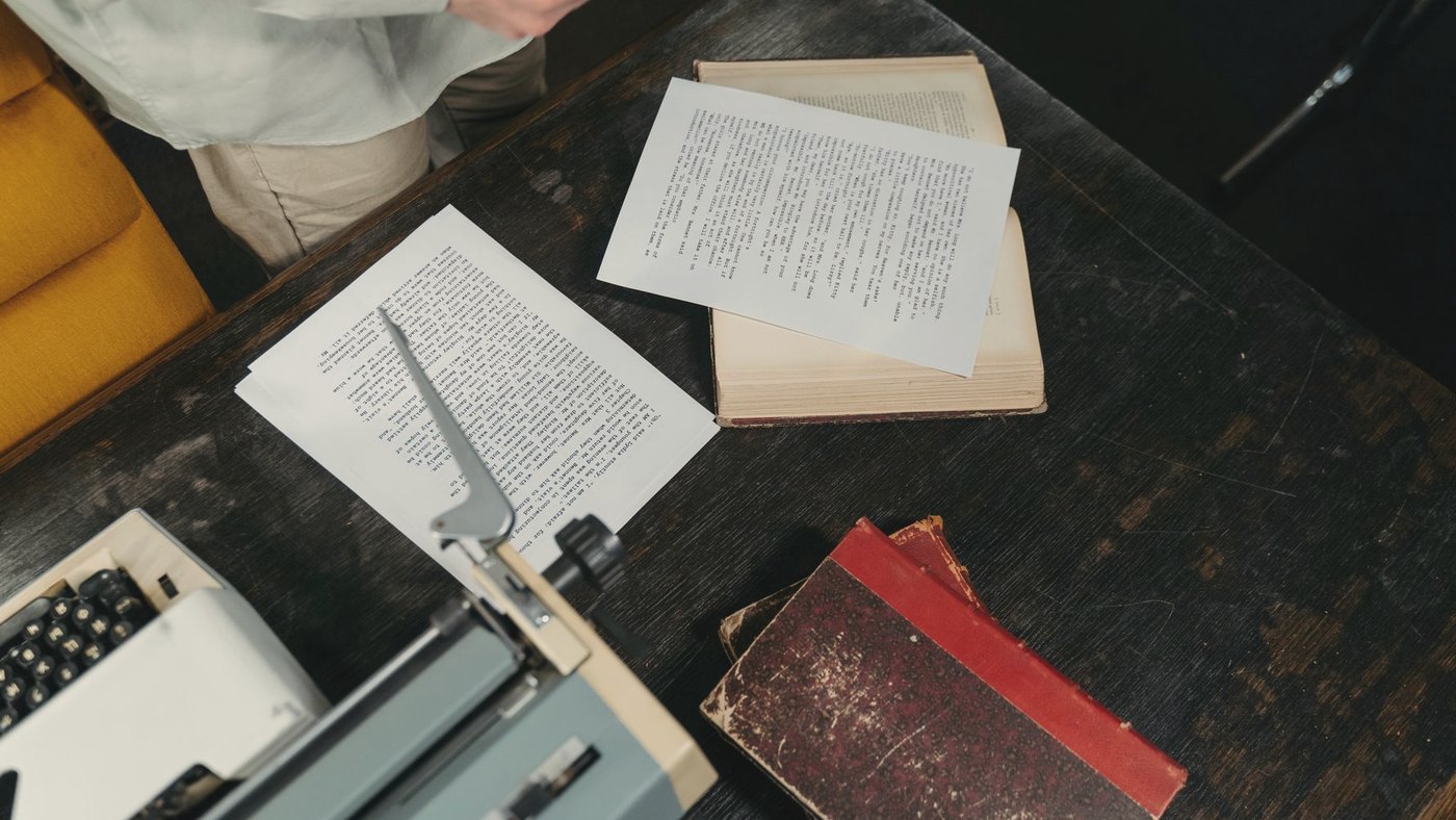 Overhead view of a wooden desk with typewriter and papers