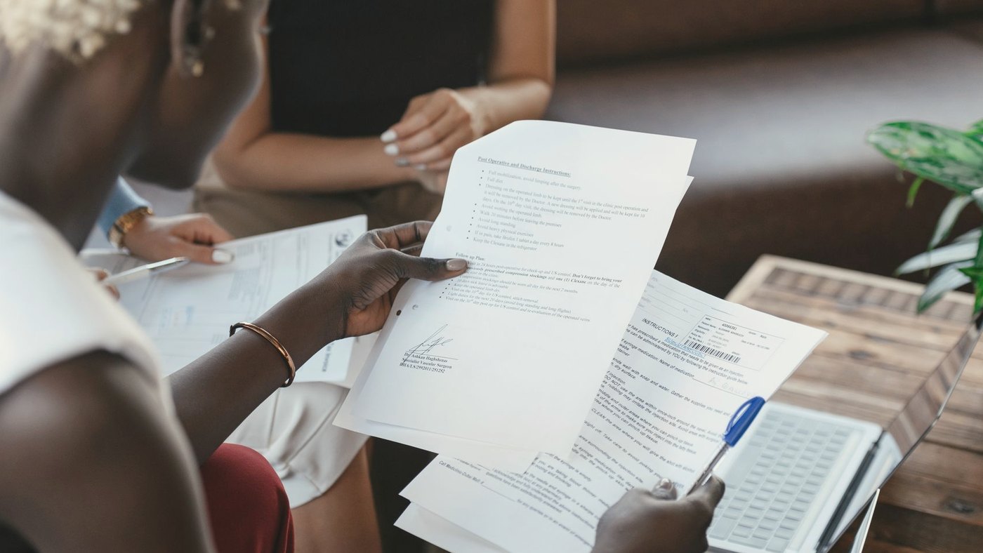 A woman at a desk compares printed data sheets