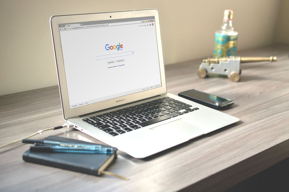 Ноутбук с поиском Google, смартфон и блокнот на деревянном столе